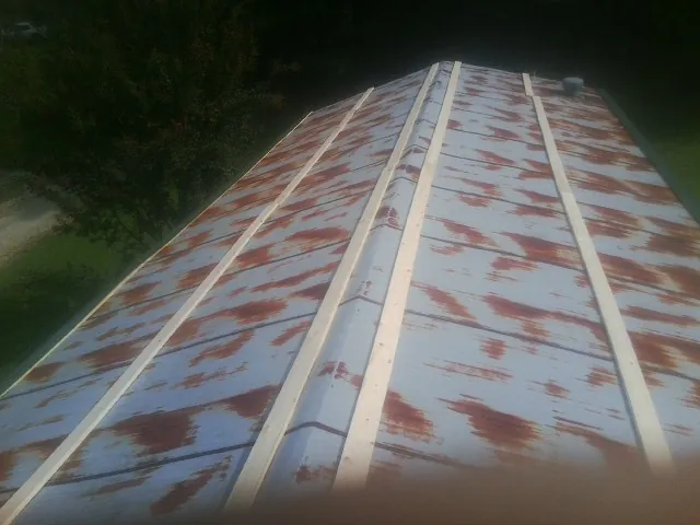 Rusted metal roof panels with new wood purlins before replacement — Storm Damage Roof Repair in Kent by Roofing Brothers